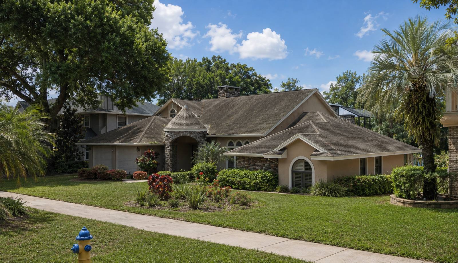 Home with a weathered asphalt shingle roof showing dark streaking and faded, worn shingles